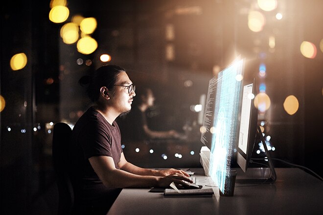 Programador informático trabajando hasta tarde en la oficina en un código nuevo